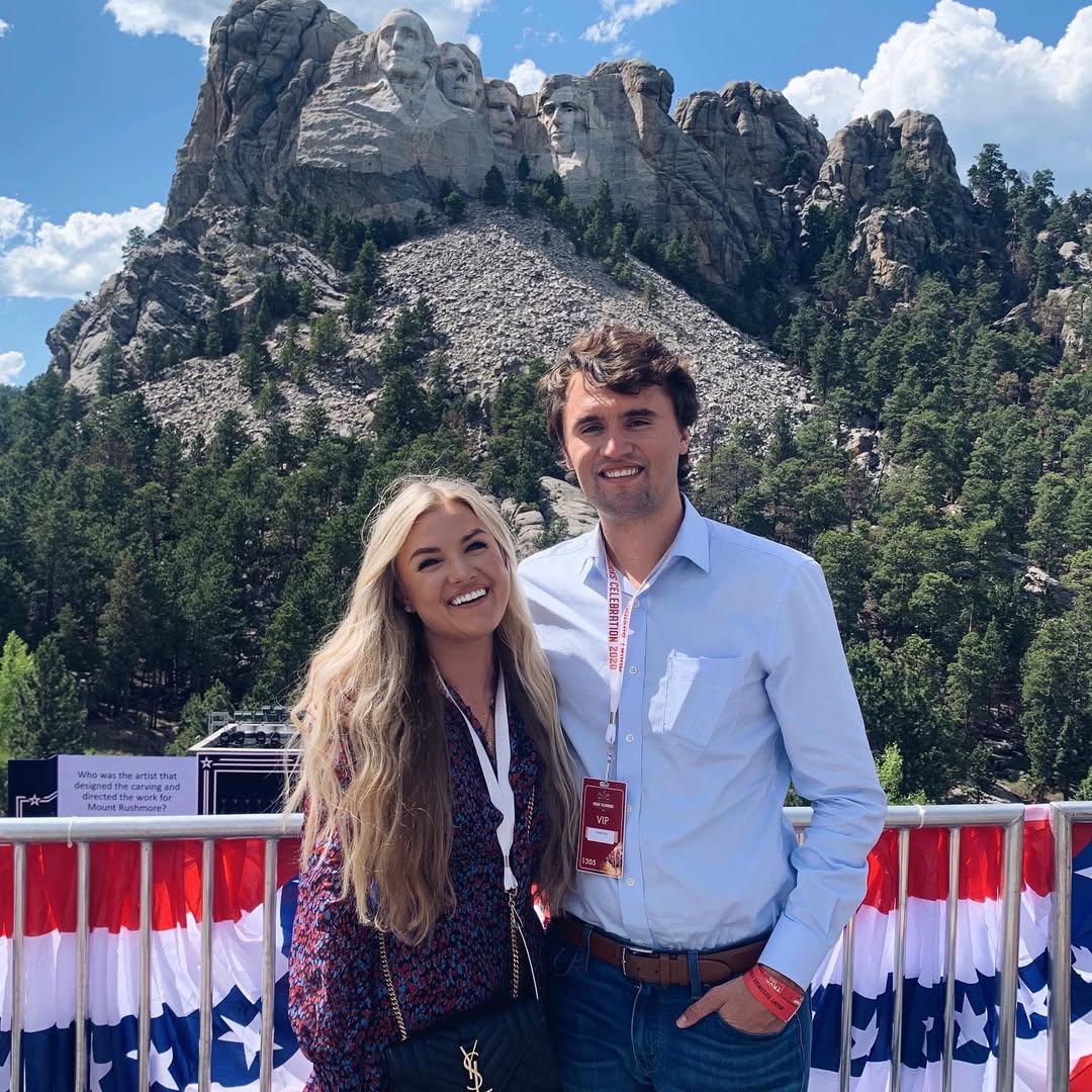 Charlie Kirk and Erika Kirk posing outside