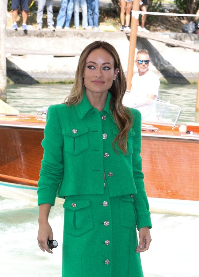 Olivia Wilde in a green blazer and skirt at a waterfront event